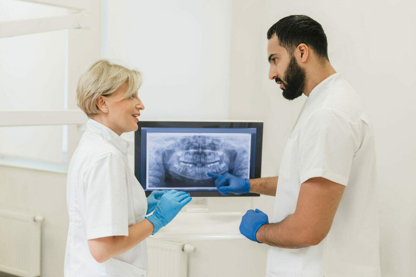 Dentists looking at the x-ray photo at computer screen